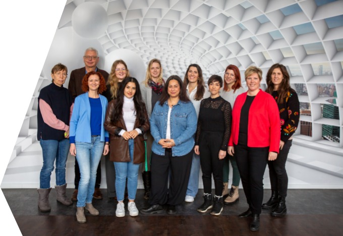 Personen vor einer Wand. Das Team der Ergotherapieschule Rosenheim.