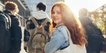 Vier Schüler*innen vor einem Schulgebäude